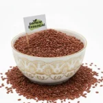 A white ceramic bowl filled with raw, nutrient-rich brown Haloon seeds featuring a small Pansar Essential brand flag.