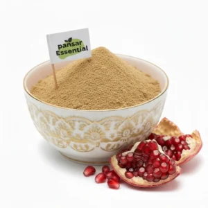 Finely ground tan pomegranate peel powder in a decorative white and gold bowl with a Pansar Essential flag, next to fresh pomegranate seeds and peel.