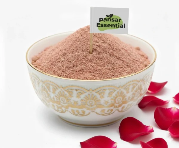 Pansar Essential organic rose petal powder in a decorative white and gold bowl with fresh red rose petals around it.